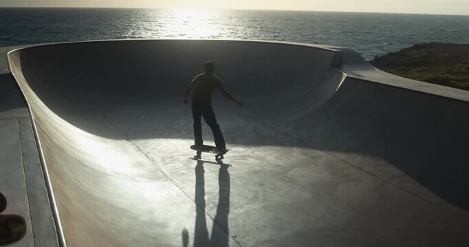 Boy having fun at skateboard park outdoor - Summer, sunset, young person lifestyle and extreme sport concept 