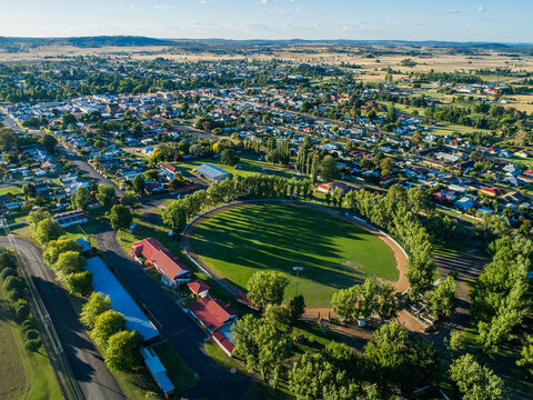 Buildings around Glen Innes Showground ring in bright sunlight from aerial view