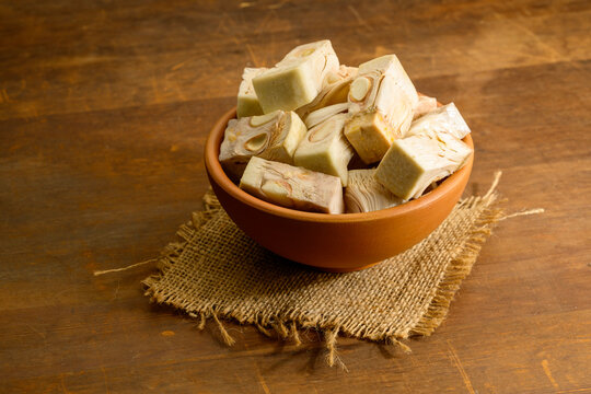 Bowl full of jackfruit pieces on wooden background