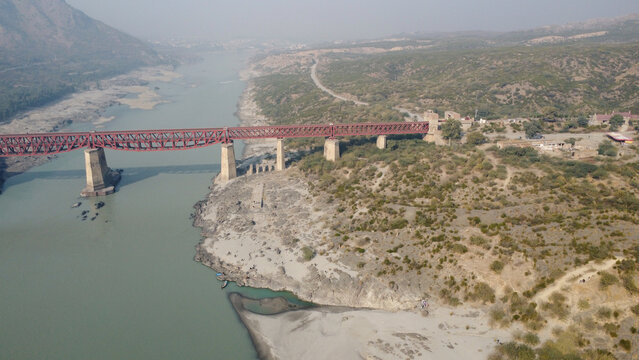 Attock khurd red steel bridge crossing indus valley in northern pakistan from aerial perspective