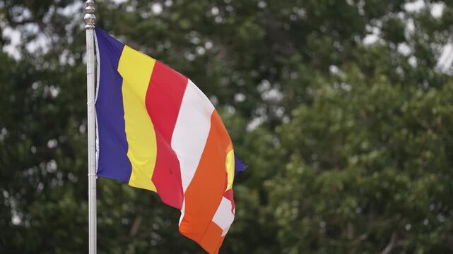 Close-up of a Buddhist flag, highlighting its vibrant multicolored stripes and symbolic representation of Buddhism