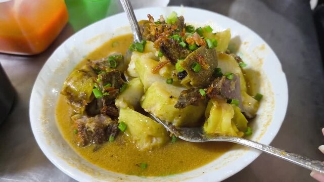 Authentic Indonesian Gulai Kambing, a traditional rich and spicy mutton curry stew cooked with coconut milk, popular local culinary cuisine from Surabaya, Indonesia.