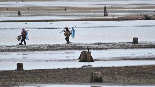 Locals Fishermans in the waterways during the dry season, while waterfowl also gather there to catch fish. Buriram, Thailand.
