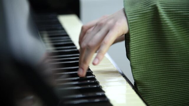 female pianist hands on black and white piano keyboard, close-up view, young woman playing piano, professional musician