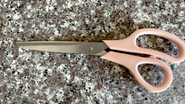 Pink Scissors on Granite Countertop Close Up Minimal Household Tool Object Flat Lay, Closeup Video