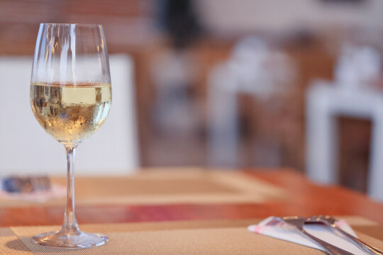 a glass of cold white wine and serving in the restaurant