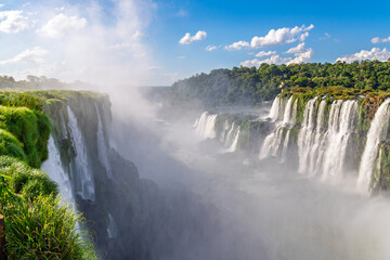 Fototapeta premium Stunning landscape of the famous Iguazu Falls with a thick mist rising from the gorge, showcasing the raw power of nature and the beauty of South America's most iconic waterfalls