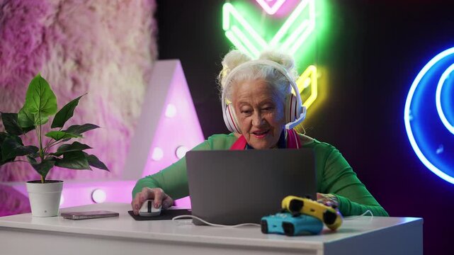 Stylish elderly woman celebrating a video game victory, excitingly gesturing yes
