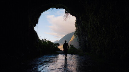 Obraz premium Person walking out of dark cave tunnel