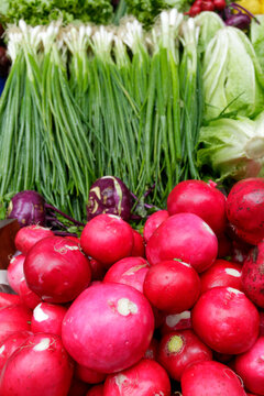 Red radishes and fresh greens at farmers market