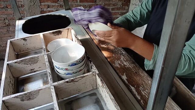 Traditional Indonesian Street Food Vendor Cleaning and Preparing Bowls for Wedang Ronde