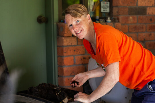 Australian woman in backyard beside worm farm