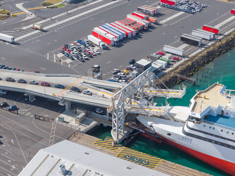 Aerial view of cars boarding a passenger ferry at a shipping terminal