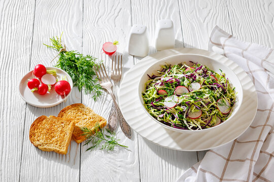 Fresh cabbage and radish coleslaw in white bowl