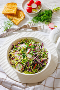 Fresh cabbage and radish coleslaw in white bowl