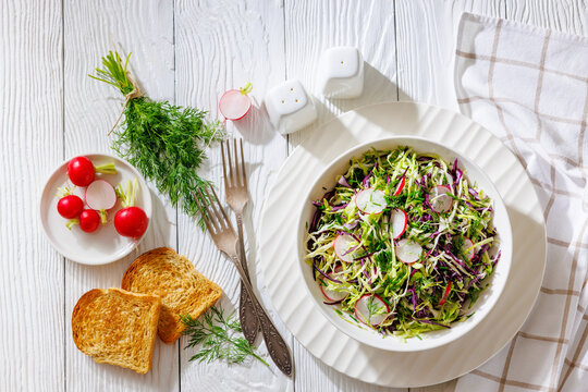 Fresh cabbage and radish coleslaw in white bowl