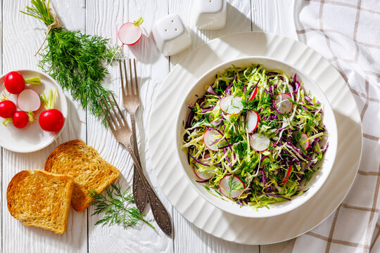 Fresh cabbage and radish coleslaw in white bowl