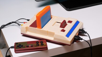 Retro video game console with a game cartridge inserted, featuring a classic controller connected, bringing back memories of childhood gaming and entertainment © Aliaksandr