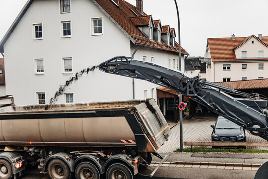 Asphalt Milling Machine Loading Old Road Surface into Dump Truck for Efficient Road Renovation Project