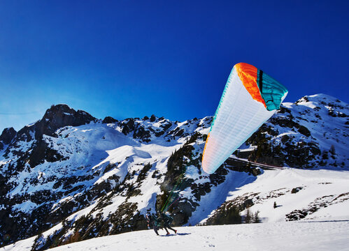 paraglider launching from a snowy mountainside in the French Alps, Chamonix, France, Europe