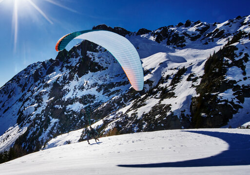 paraglider launching from a snowy mountainside in the French Alps, Chamonix, France, Europe