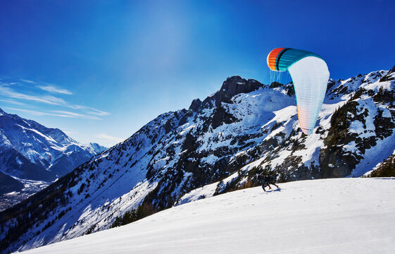 paraglider launching from a snowy mountainside in the French Alps, Chamonix, France, Europe