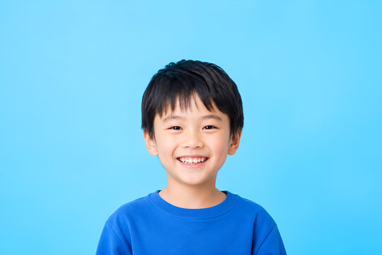 こどもの日に使える歯が見える笑顔の日本人男の子ポートレート ビビッド単色背景 コピースペース 明るい子供イメージ -生成AI