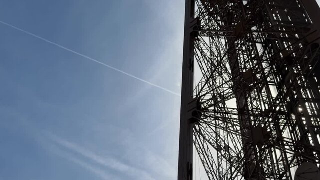Eiffel Tower's intricate iron lattice structure silhouetted against a bright, clear sky, capturing the iconic architecture and engineering of the famous Paris landmark