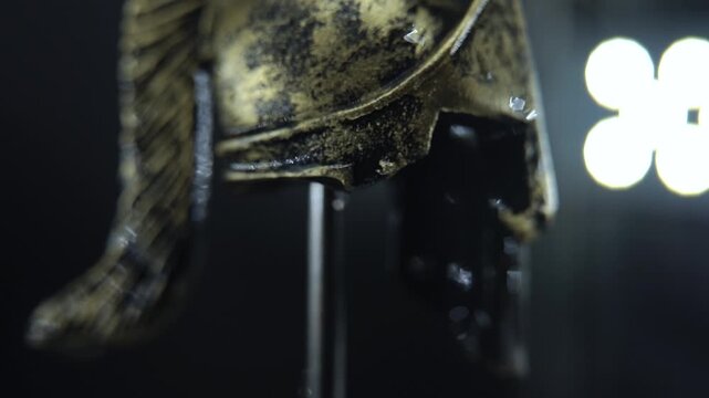 Gladiator helmet macro footage, 360 spin, water drop falls, dramatic cinematic lighting 120 fps slow motion
