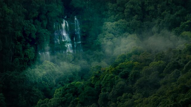 Misty waterfall hidden in dense rainforest canopy of Meghalaya India