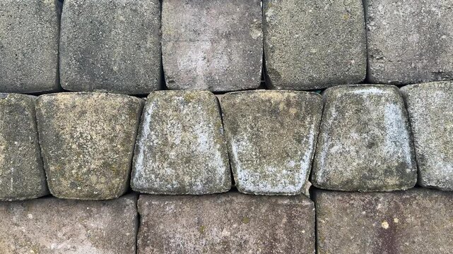 Top view paving stone samples display, close-up texture of coarse concrete pavers arranged on retail stand, neutral tan and gray