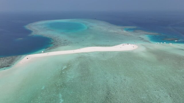 aerial drone view of tropical lagoon with sandbank and turquoise water, coral reef and boats
