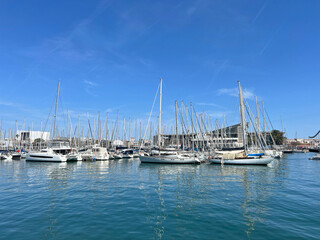 Fototapeta premium Luxury yachts and sailboat masts reflecting in calm blue water. Abstract nautical background for travel, charter, waterfront real estate and lifestyle branding.