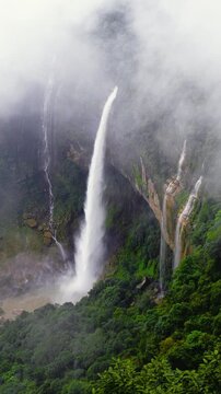 Majestic nohkalikai Waterfall of Meghalaya Cascading Down High Cliff into Mist, Lush Green Tropical Forest Mountainside with Foggy Atmosphere and Scenic Nature Landscape
