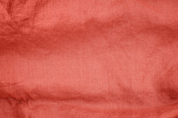 Fototapeta premium Red fabric with a woven texture is displayed on a simple background in a well-lit setting during daylight hours