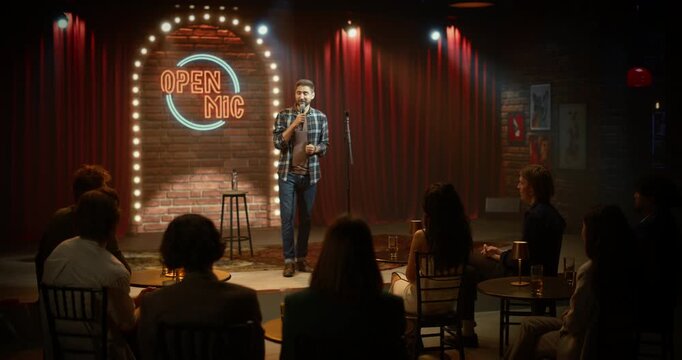 Male Comedian Delivers a Live Stand-up Comedy Club Stage Performance at Open Mic Night, Telling Funny Jokes as the Audience Is Having Fun in a Bar Venue Entertainment Show.