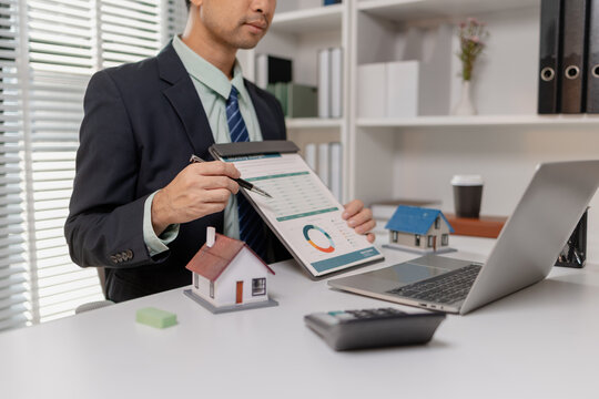 Businessman presenting budget report with property model, explaining financial data, housing cost, and investment planning, representing real estate finance and decision making process.