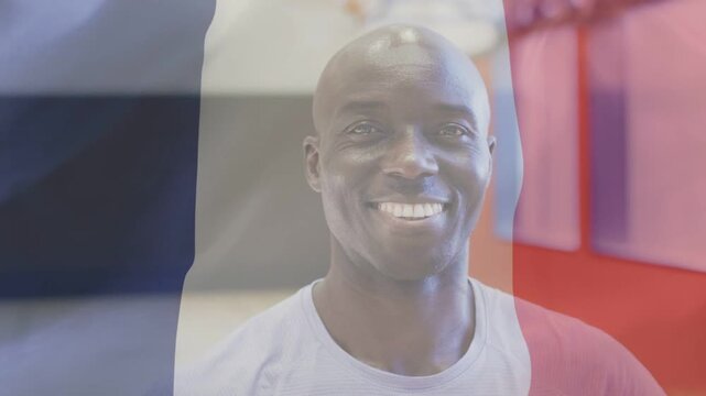 Mature man softening into broad smile while French flag shifting and white logo emerging for brand