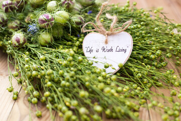 Handmade sign on decorative plant arrangement with natural elements in indoor setting © Fleuronica