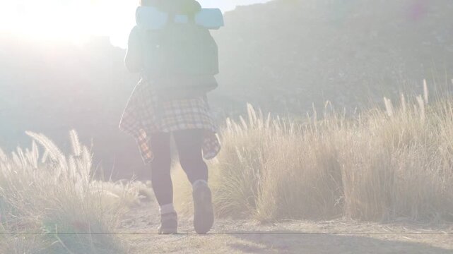 Boot shot kicking dust, woman walking travel trail, carrying backpack, heading to camp