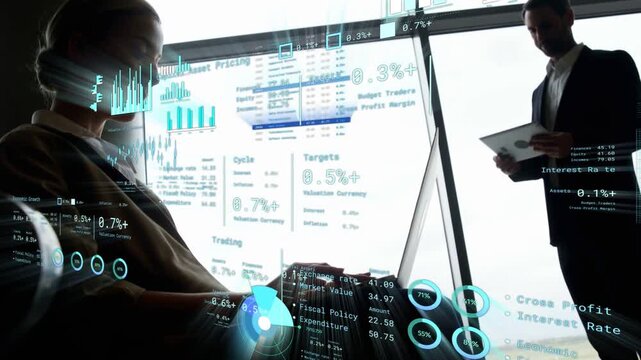 Woman typing laptop causing HUD finance charts updating, man reviewing docs and analyzing data