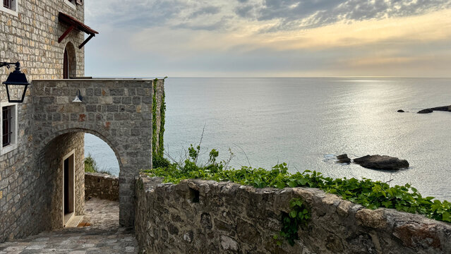 Ulcinj Old Town stone walkway overlooking calm Adriatic Sea at spring sunset