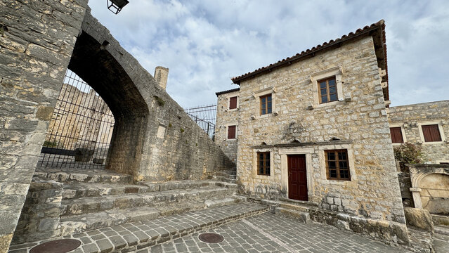 Ulcinj Old Town stone arch and historic limestone houses under cloudy spring sky