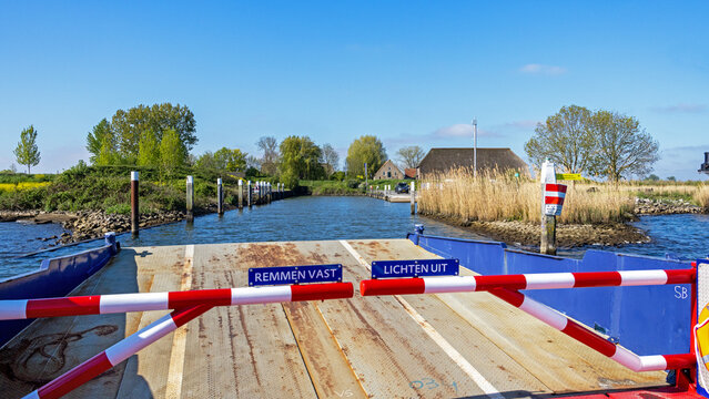Ferry arriving at the isle of Tiengemeten, a Natura 2000 nature reserve in South Holland province, Netherlands; with safety instructions (in Dutch), on a sunny day in spring