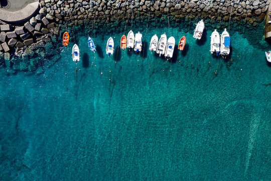 Drone aerial view of a sandy beach and blue sea captured from above on a hot summer day. The composition shows the meeting of shoreline and water with vibrant colors and natural patterns. Perfect conc