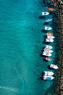 Drone aerial view of a sandy beach and blue sea captured from above on a hot summer day. The composition shows the meeting of shoreline and water with vibrant colors and natural patterns. Perfect conc