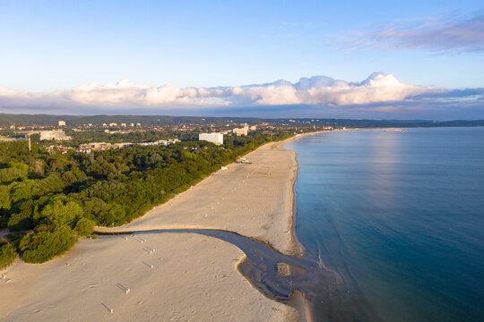 Drone aerial view of a sandy beach and blue sea captured from above on a hot summer day. The composition shows the meeting of shoreline and water with vibrant colors and natural patterns. Perfect conc