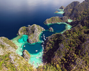 Aerial view of Big Lagoon in El Nido, Palawan, Philippines. Limestone karst islands surrounded by crystal-clear turquoise water with traditional boats anchored in a tropical paradise. © akturer