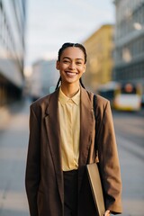 Obraz premium Young professional woman smiling on city sidewalk during daytime
