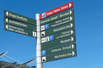 Obraz premium Wegweiser für Fußgänger vor dem Bahnhofsplatz, sehenswerte Ziele in der Stadt Siegen
